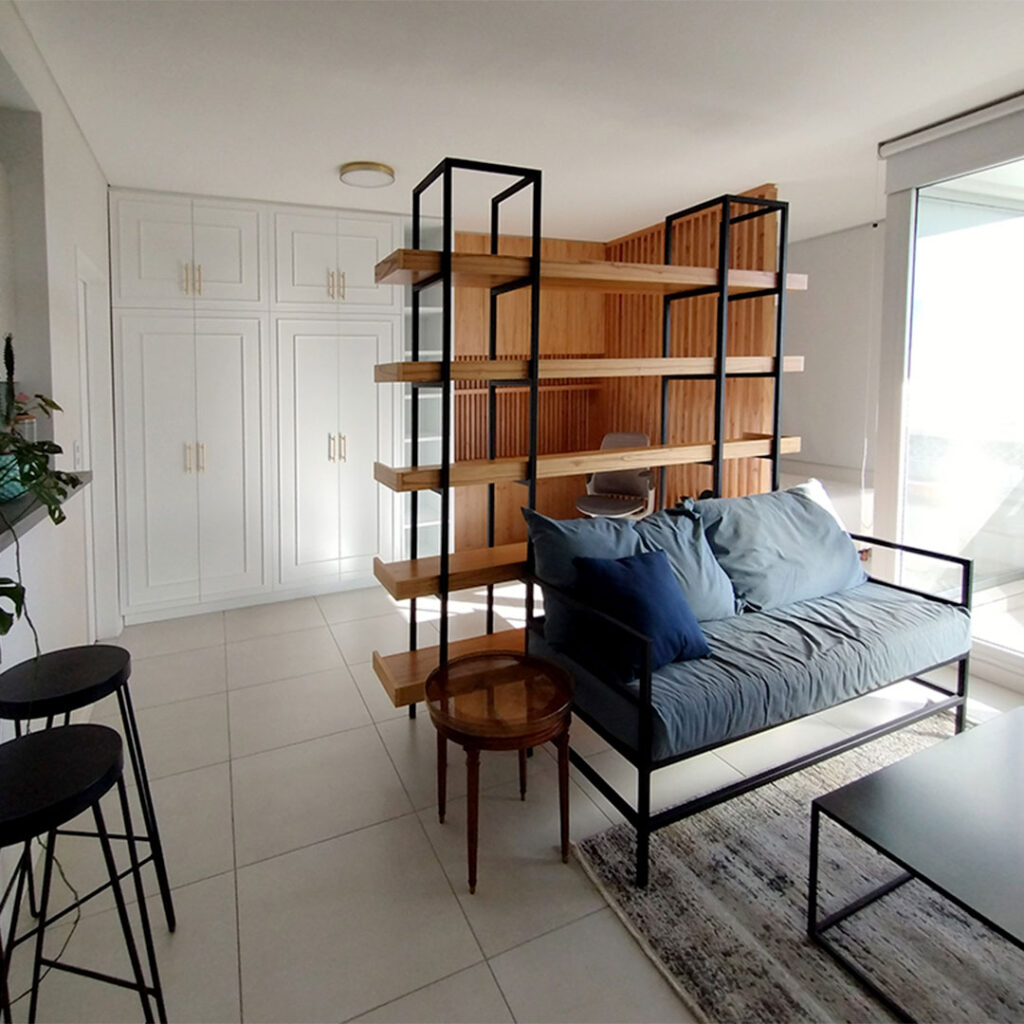 Vista general de mobiliario a medida para monoambiente en caba, con terminación laqueda blanca y enchapado paraiso.