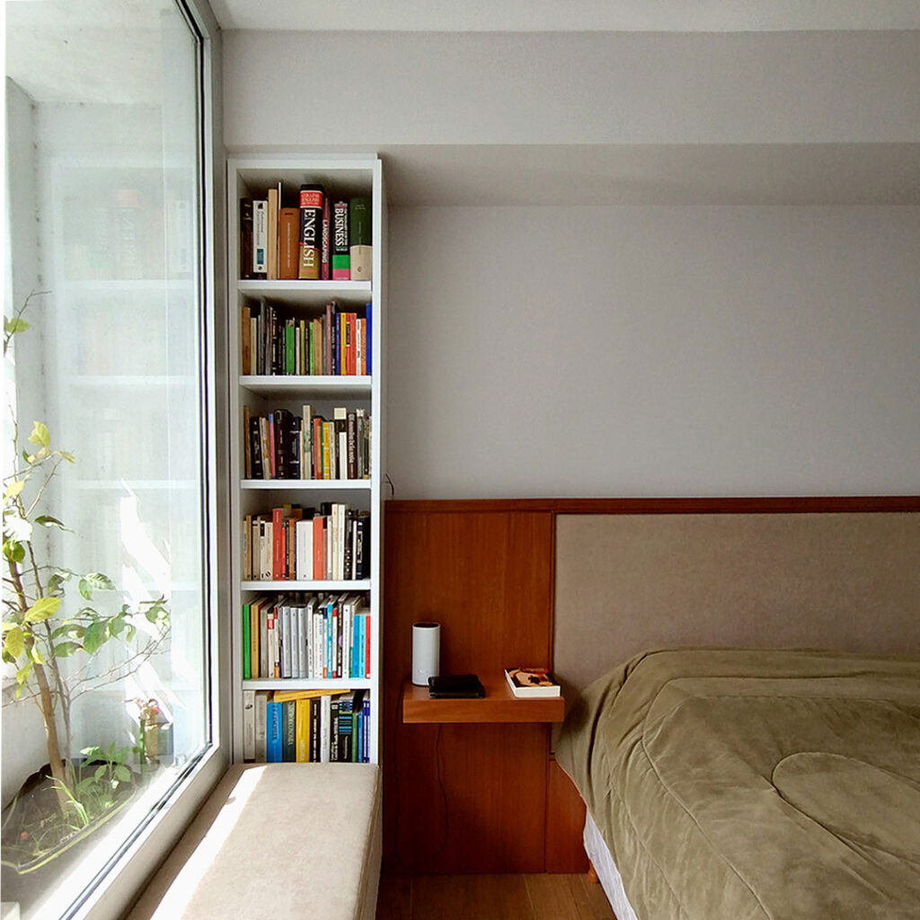 Biblioteca laqueada y Respaldo de cama a medida en madera enchapada lenga con tapizado en tono neutro para dormitorio principal.