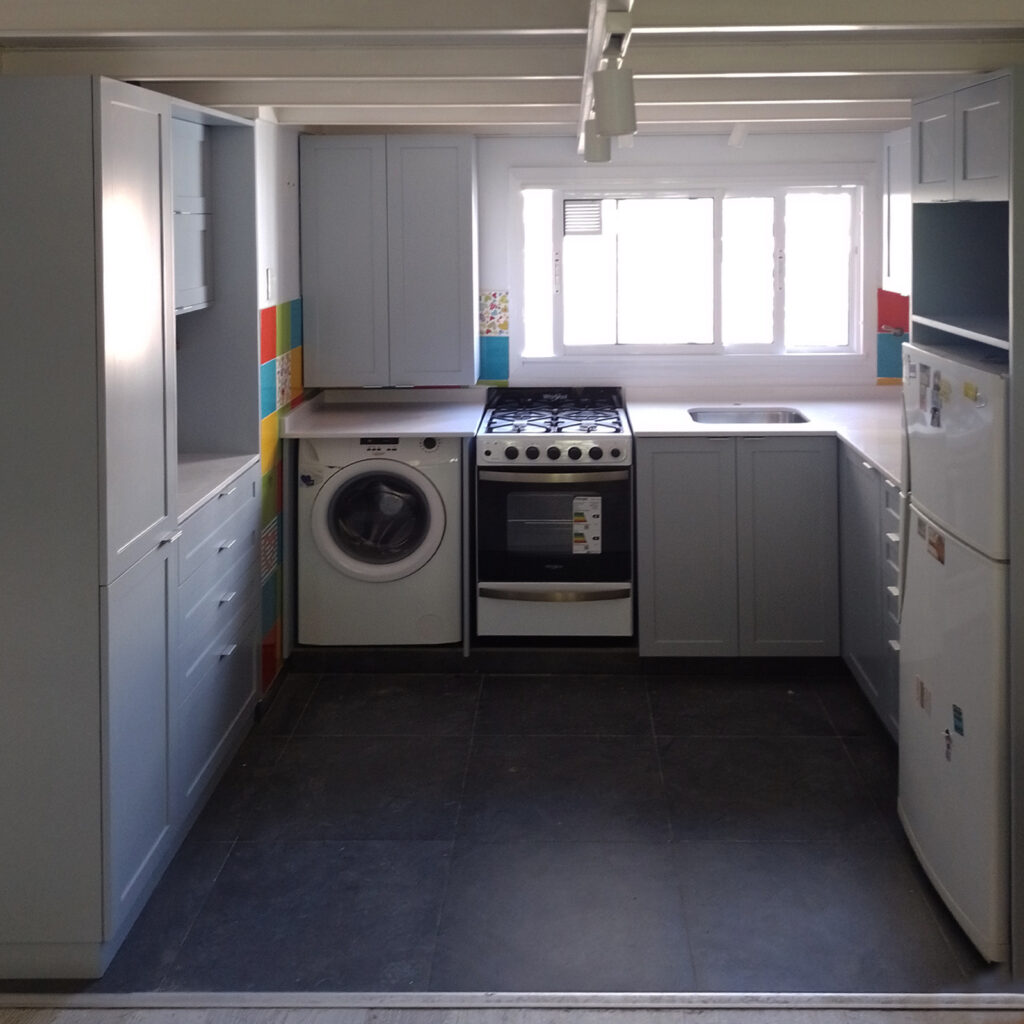 Vista frontal de cocina laqueada color ceniza con frentes moldurados y diseño clásico moderno.