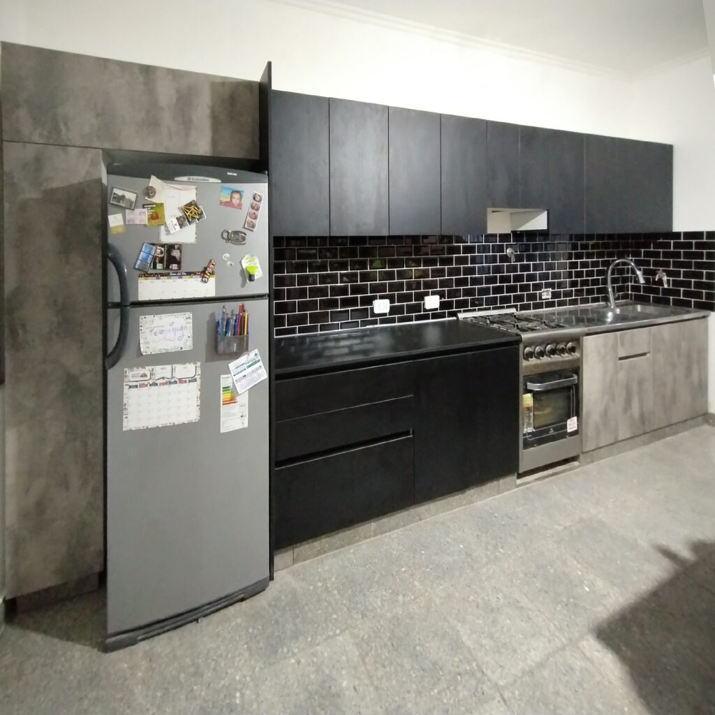 Vista frontal de cocina moderna con alacenas abiertas y sistemas extraíbles en melamina sauco y street.