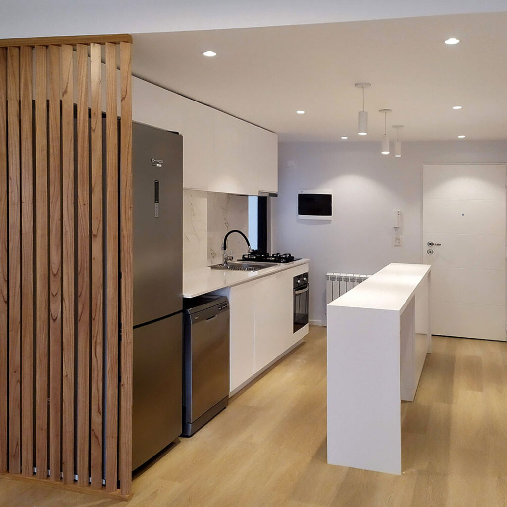 Vista general de la cocina moderna a medida con terminaciones premium y mesada en silestone claro.