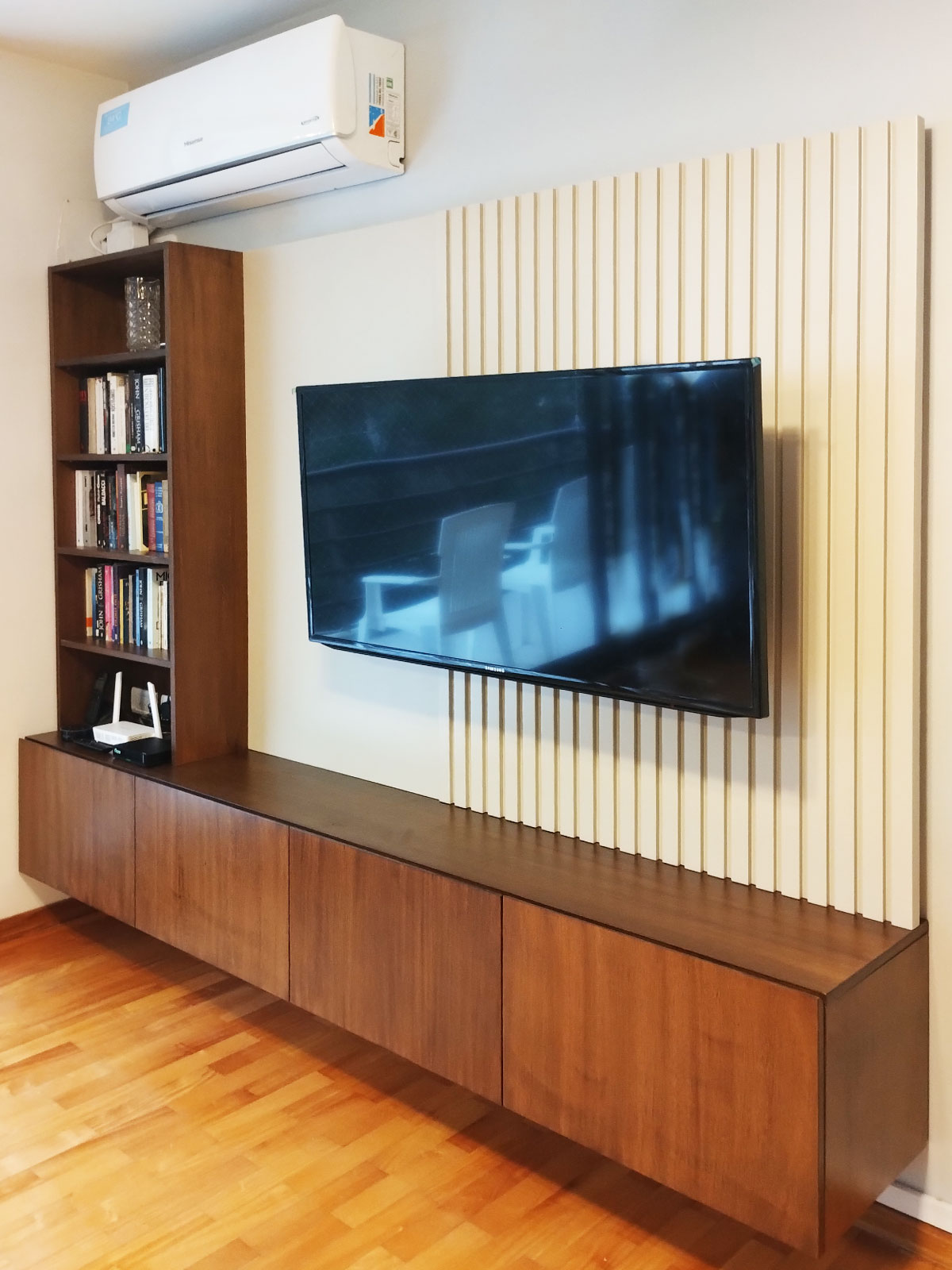 vista lateral de mueble de tv con biblioteca enchapada y panel varillado laqueado